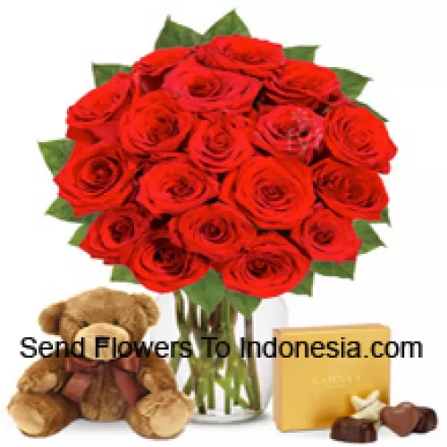 12 Red Roses With Some Ferns In A Glass Vase Accompanied With An Imported Box Of Chocolates And A Cute 12 Inches Tall Brown Teddy Bear