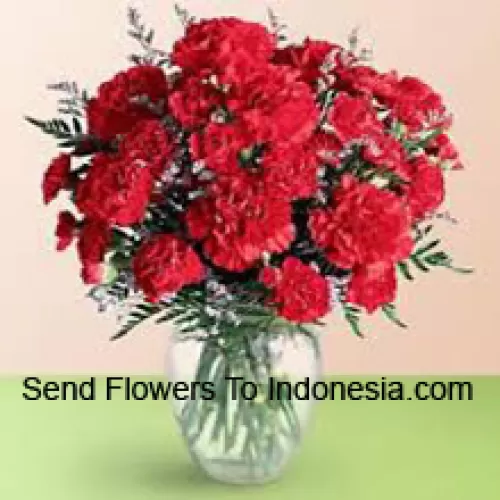 36 Red Carnations With Seasonal Fillers In A Glass Vase