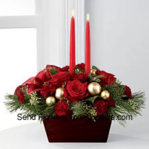 An exquisite display of holiday beauty to add warmth and cheer to their special celebrations. Rich red roses and burgundy mini carnations are set to impress surrounded by lush holiday greens, seeded eucalyptus, gold glass balls and a gold-edged red ribbon arranged elegantly around two red taper candles. Presented in a chocolate brown bamboo container, this centerpiece will usher in joy and goodwill with each treasured bloom (Please Note That We Reserve The Right To Substitute Any Product With A Suitable Product Of Equal Value In Case Of Non-Availability Of A Certain Product)